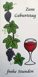 Vergrößerungsansicht: Weinranke mit Trauben und gefülltem Rotweinglas