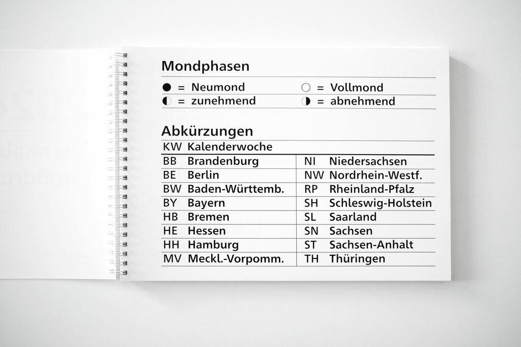 Aufgeklappter Großdruck-Tischkalender 2024 im Querformat mit Mondphasen und Akürzungsverzeichnis