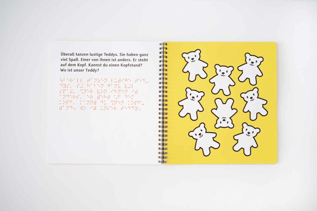 Aufgeschlagenes Ringbuch mit Teddybären in tastbaren Lack-Konturen, Großdruck und Braille-Schrift