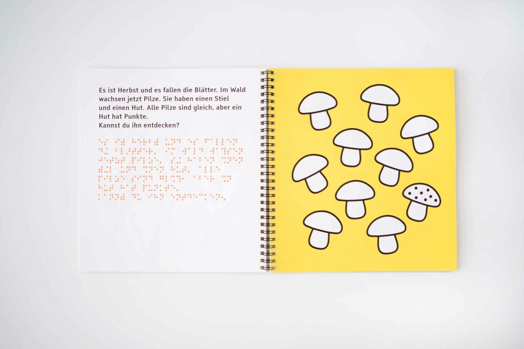 Aufgeschlagenes Ringbuch mit Pilzen in tastbaren Lack-Konturen, Großdruck und Braille-Schrift