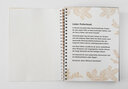 Vergrößerungsansicht: Aufgeschlagenes Ringbuch mit Braille-Schrift und Großdruck, umrahmt von Tannenzweigen
