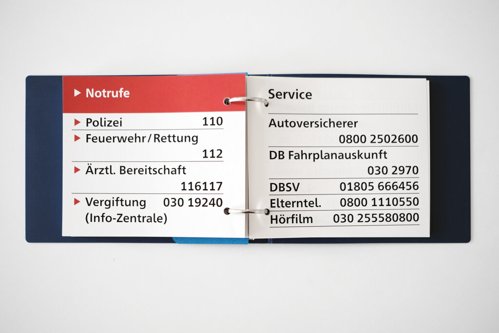 Geöffneter Großdruck-Taschenkalender mit Notruf- und Service-Telefonnummern