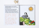 Vergrößerungsansicht: Aufgeklapptes Ringbuch mit Text in Großdruck und Braille-Schrift sowie tastbarer Abbildung von einem hoppelnden Kaninchen auf einer grünen Wiese im Sonnenschein