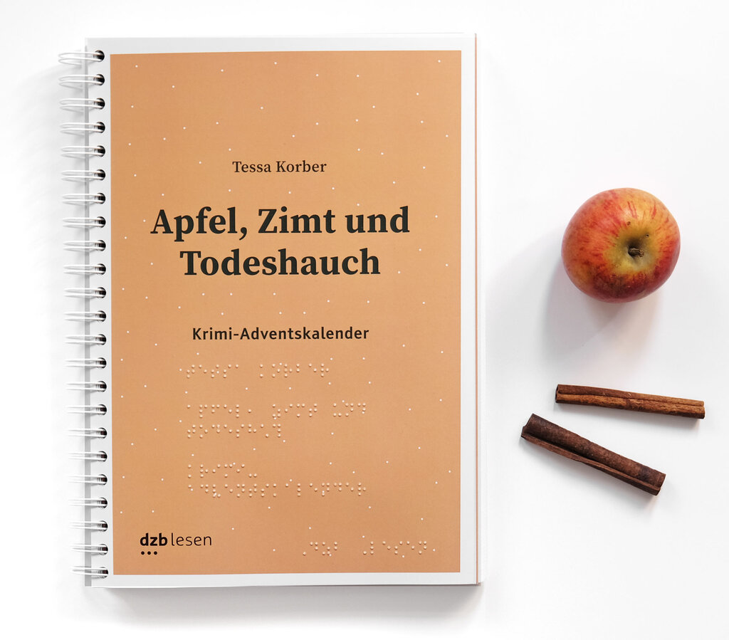 Deckblatt vom Krimi-Adventskalender Apfel, Zimt und Todeshauch in Brailleschrift und Großdruck auf weißem Hintergrund, rechts daneben liegen ein Apfel und Zimtstangen.