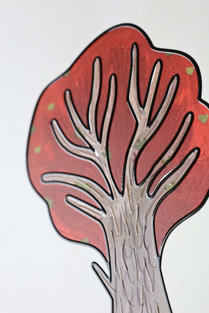 Eine Baumkrone mit rot gefärbten blättern und dicken gebogenen Ästen