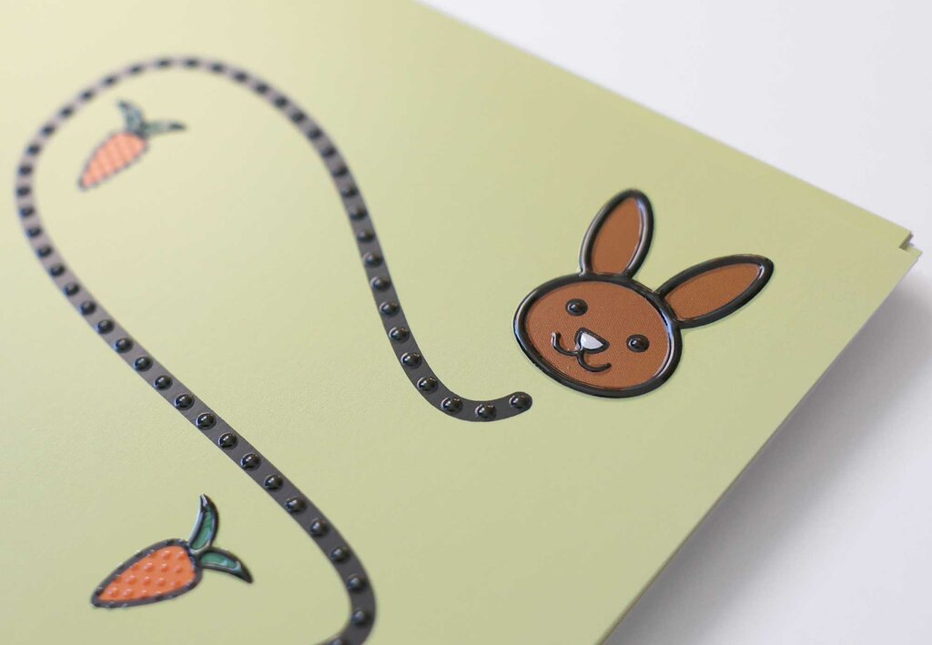 Detailaufnahme von einem Hasenkopf und Mohrrüben, die entlang einer geschlängelten Punktelinie angeordnet sind