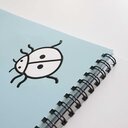 Vergrößerungsansicht: Detailaufnahme von einem taktilen Marienkäfer, kontrastreich gedruckt in fühlbaren Lackkonturen.