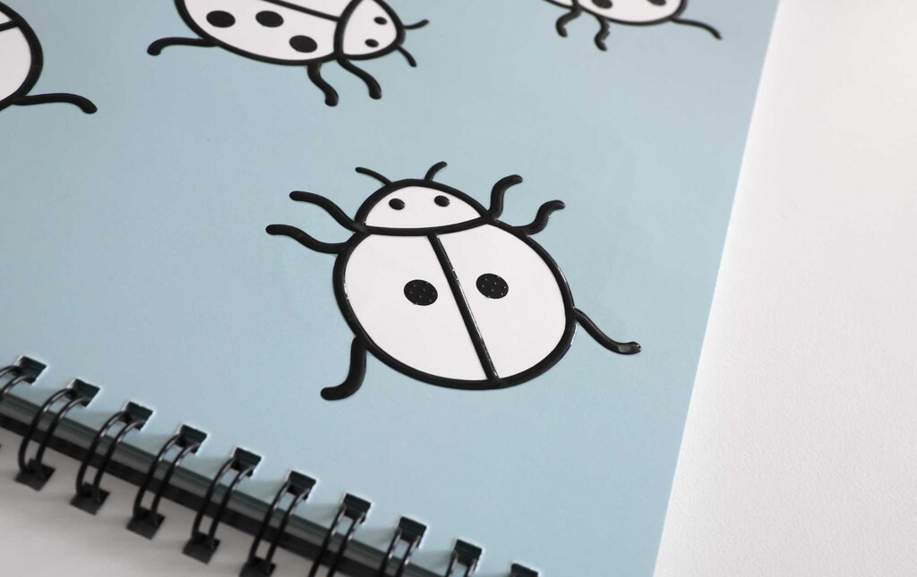 Detailaufnahme mehrerer tastbarer Marienkäfer, kontrastreich gedruckt in fühlbaren Lackkonturen.