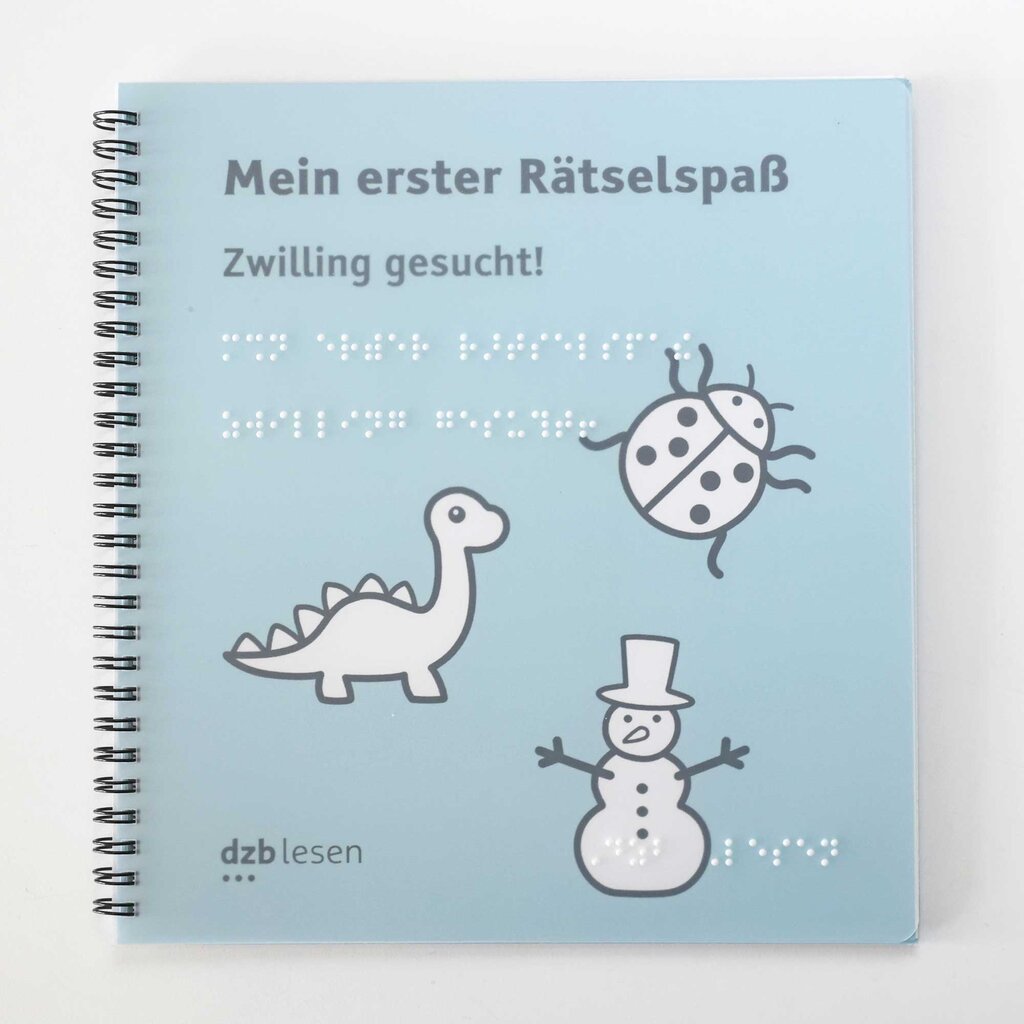 Buchcover des Heftes »Mein erster Rätselspaß - Zwilling gesucht«. Unter dem Buchtitel in großer Schrift und Brailleschrift sind drei Motive abgebildet: Ein Dinosaurier mit langem Hals, ein Marienkäfer mit sechs Punkten sowie ein Schneemann mit Hut.