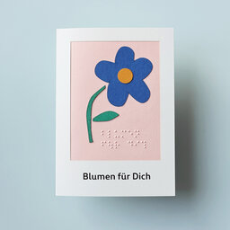 Klappkarte mit blauem Blümchen und Text in Brailleschrift und Großdruck