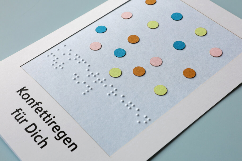 Detailaufnahme von taktil gestalteter Grußkarte mit aufgeklebten Pünktchen in verschiedenen Farben.