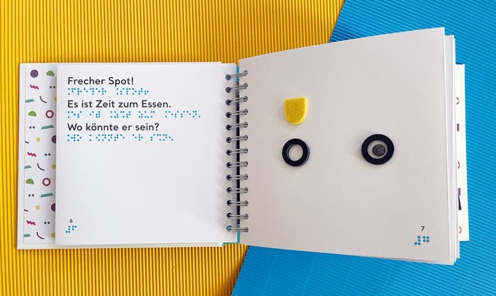 Geöffnetes Buch mit Großdruck und taktiler Abbildung