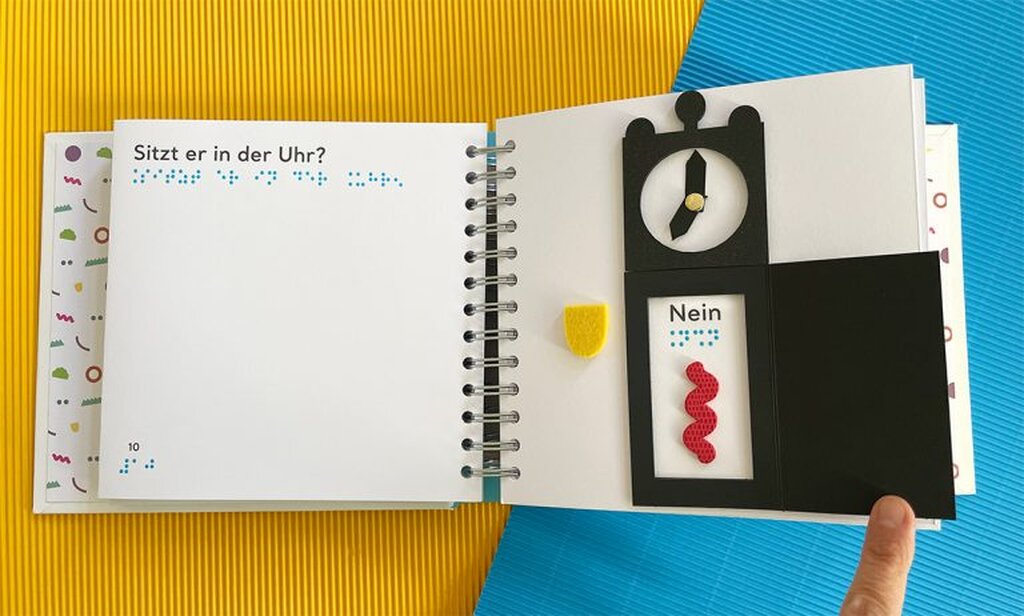 Geöffnetes Buch mit Großdruck und taktiler Abbildung