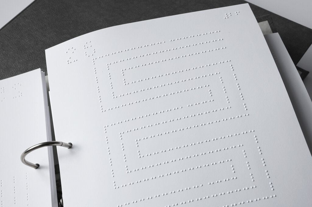 Gedruckte Seite mit geschlängelten Linien aus tastbaren Punkten.