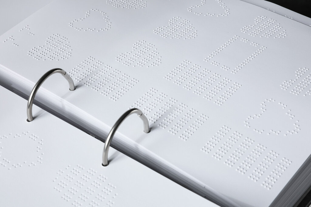 Detailaufnahme einer Seite mit tastbaren Formen und Mustern.