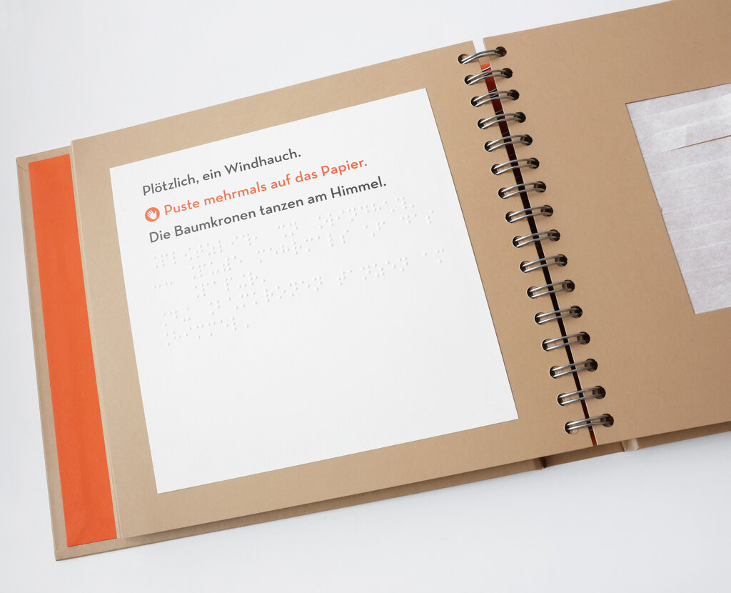 Aufgeschlagene Buchseite mit Text in Brailleschrift und Großdruck.
