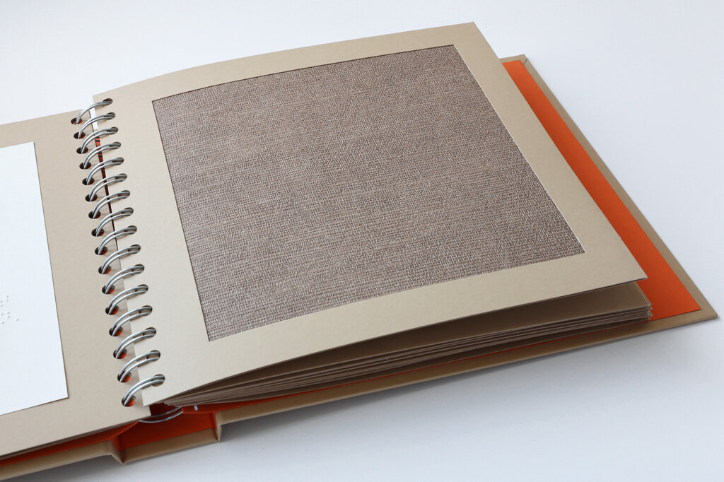 Taktil gestaltete Buchseite mit einer rauen Papierfläche.