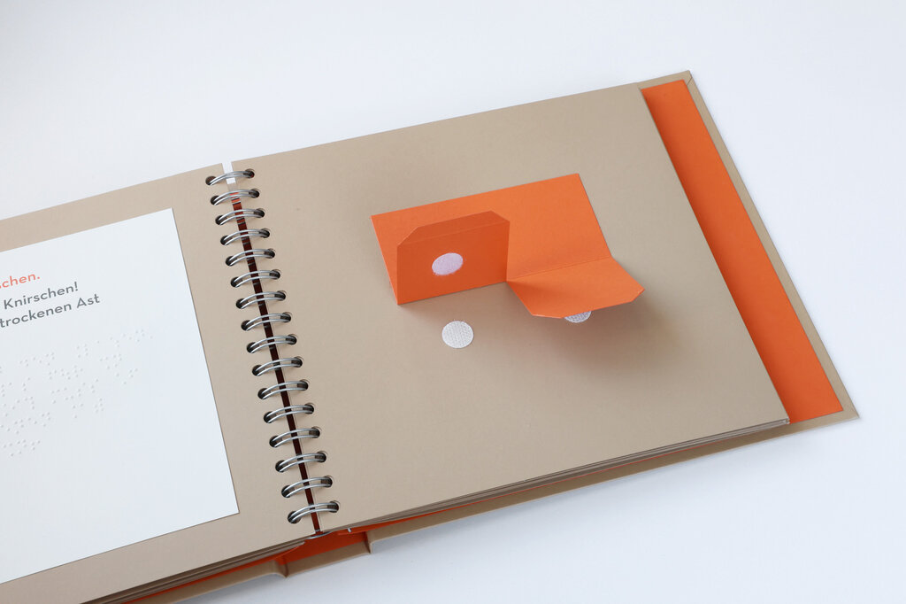 Taktil gestaltete Buchseite mit beweglichen Papierelementen.